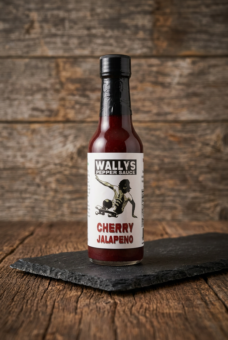 Cherry Jalapeño pepper sauce bottle on black slate on a wood table