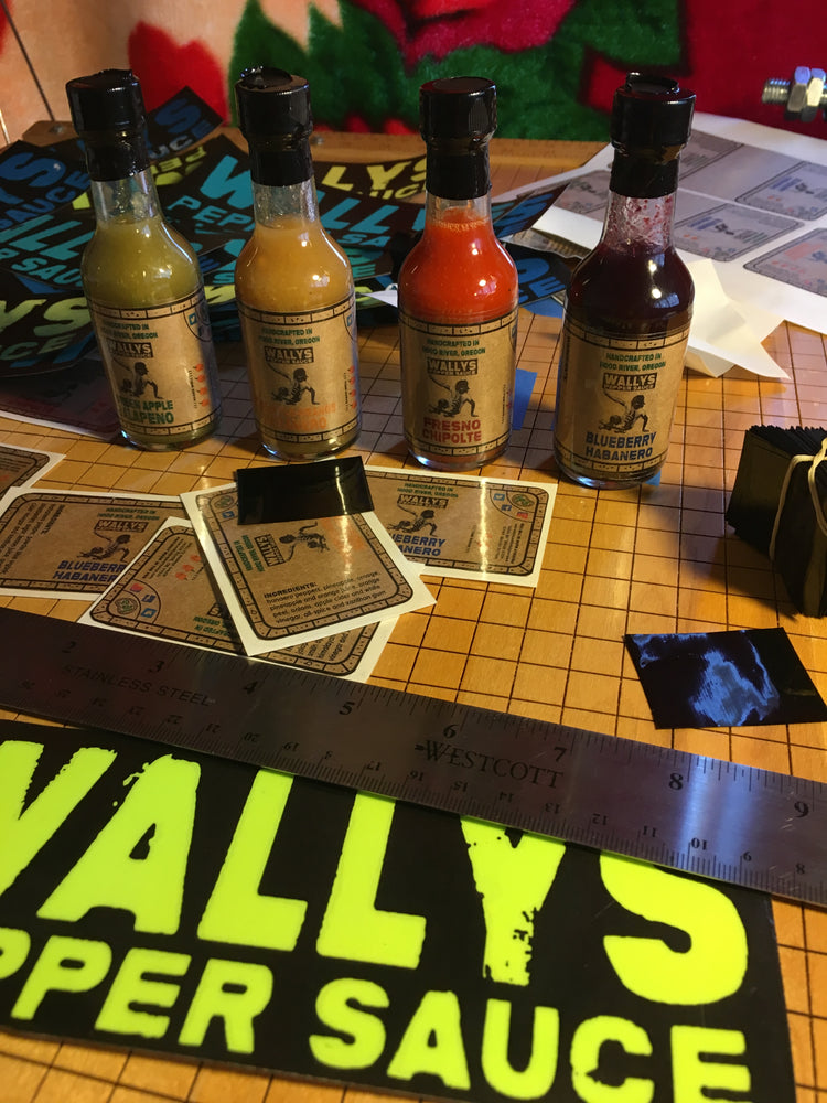 Wally hand-labeling early bottles of Wallys Pepper Sauce on his workbench
