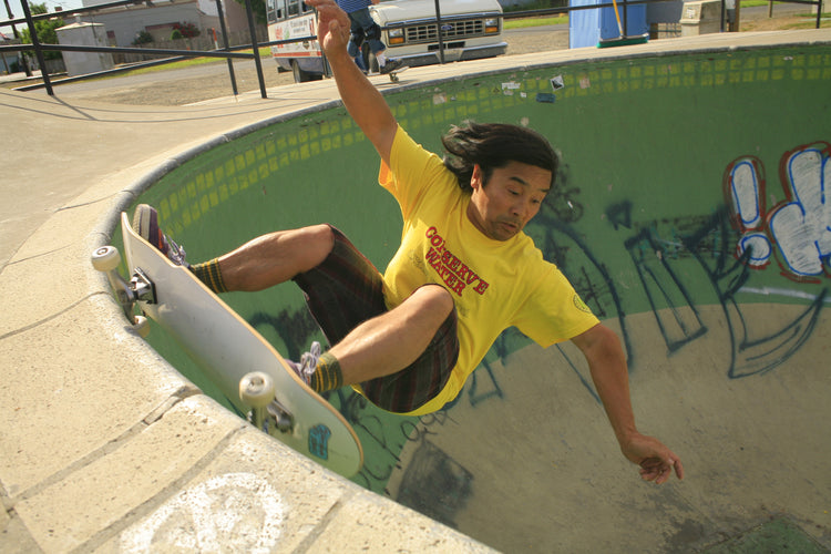 Wally carving a backyard-style concrete pool in a yellow shirt