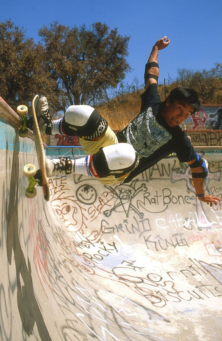 Wally carving a graffiti-covered concrete wall