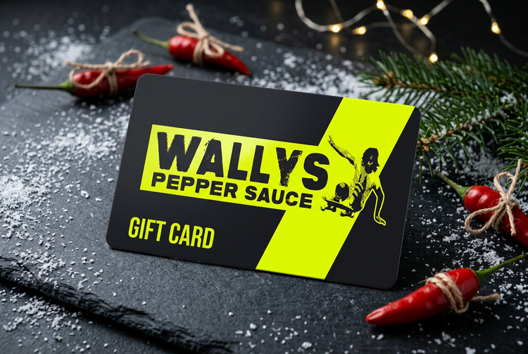 Wallys Pepper Sauce gift card with chili ornaments, evergreen and snow for Christmas